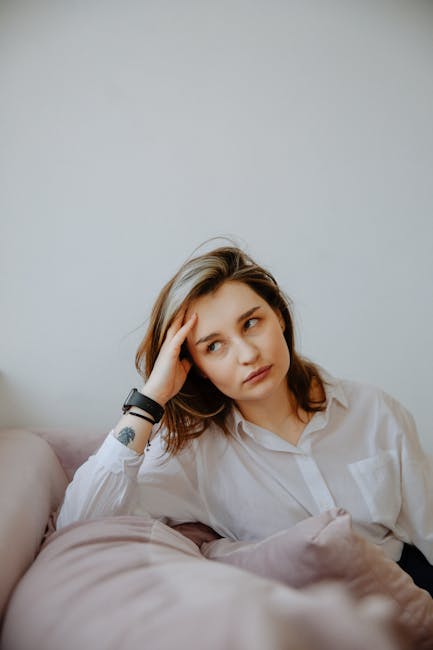 A person sitting at a desk with good posture looking away thoughtfully, implying a moment of mindful pause.