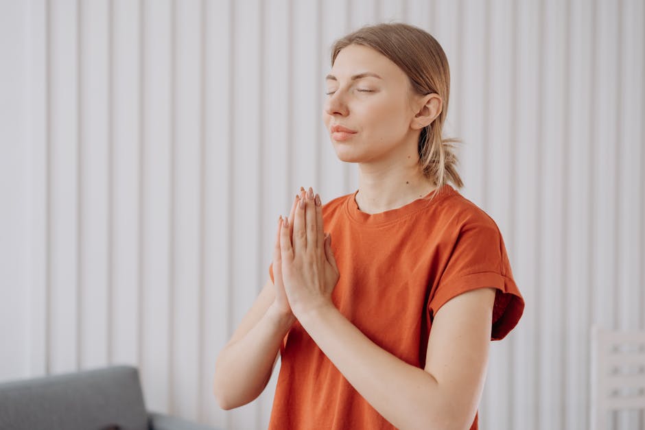 A serene woman in a comfortable yoga pose, eyes closed, in a dimly lit room suggesting evening relaxation.